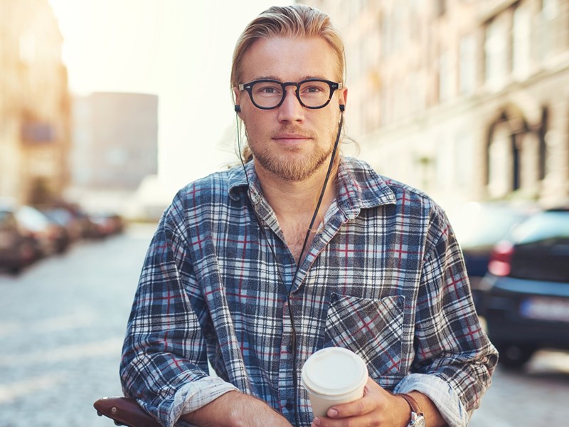 Man står vid sin cykel med kaffemugg i handen.